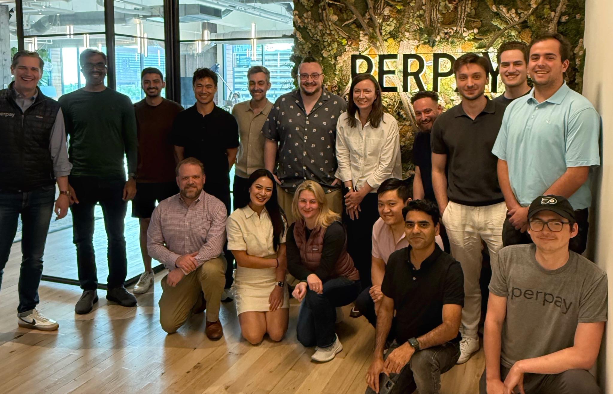 The team gathered in front of the Perpay sign in the office.